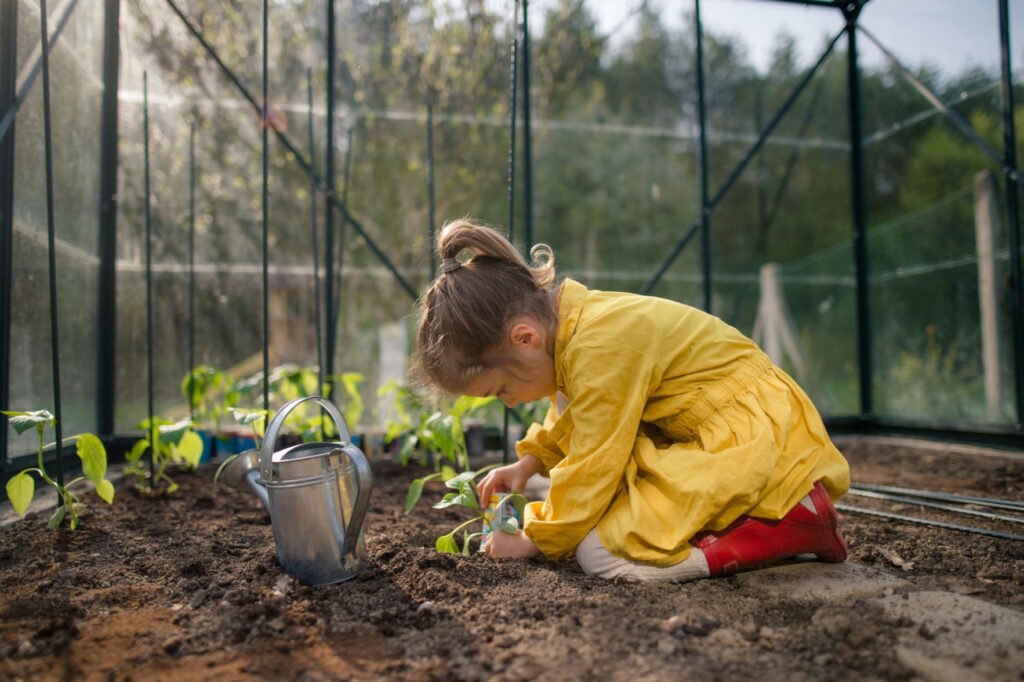 Petite fille plantant une semence dans un jardin