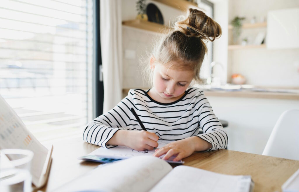 Fillette faisant ses devoirs dans la cuisine