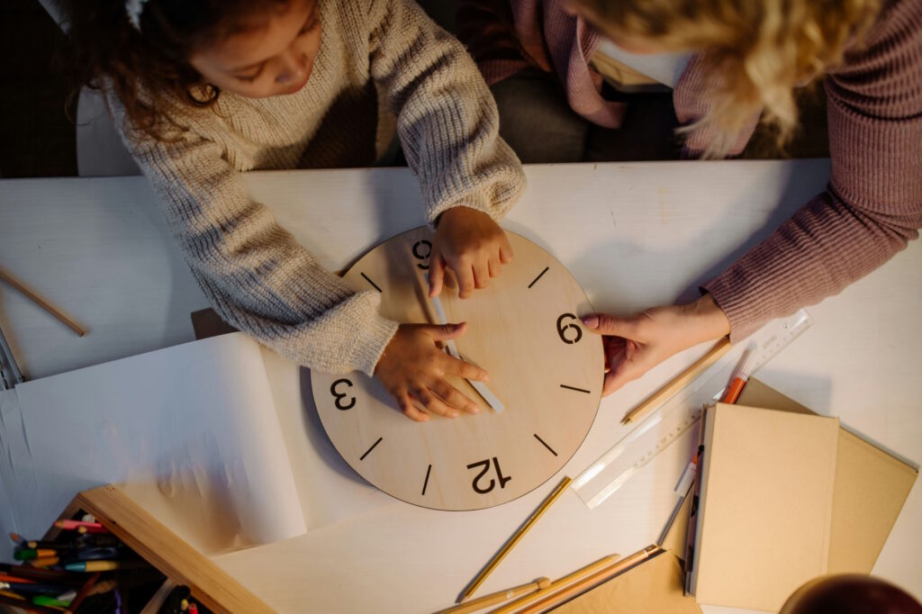 Fillette qui apprend à lire l'heure avec sa maman