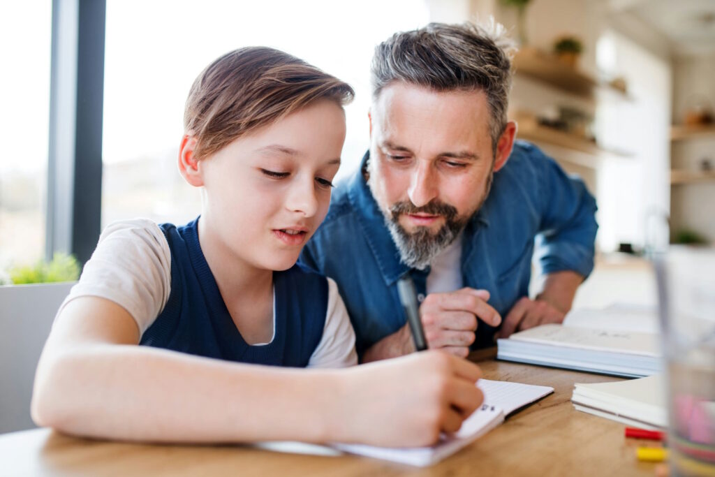 Papa qui aide son fils à faire ses devoirs et leçons