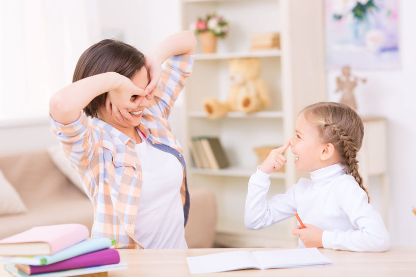 Maman guidant son enfant dans le plaisir lors d’une séance de devoirs à la maison