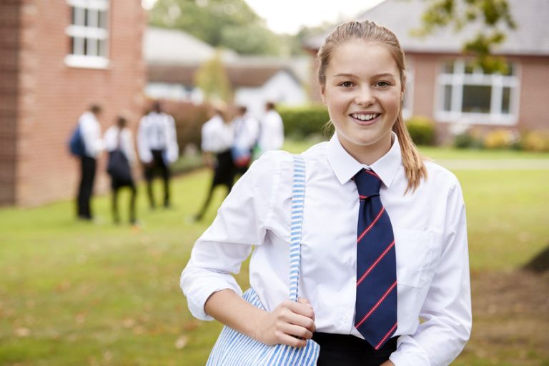 Jeune adolescente heureuse devant son collège privée